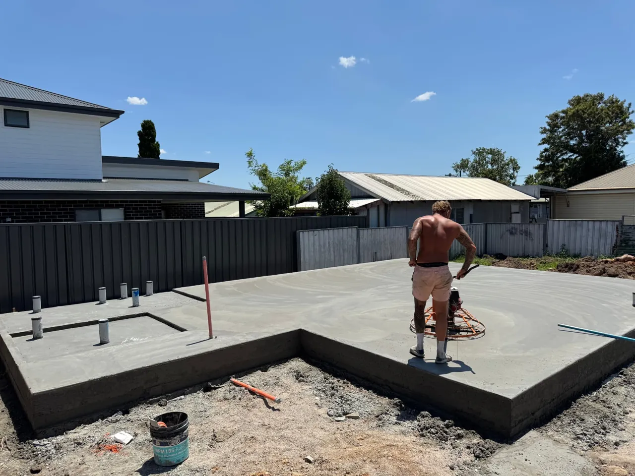 Concrete slab being finished with a power trowel on a Central Coast build