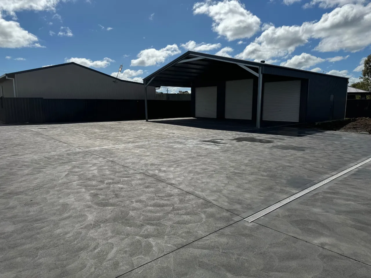 Wide decorative concrete slab and carport apron at a Central Coast property